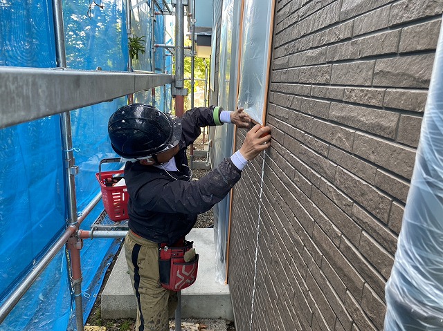 上伊那郡飯島町：外壁塗装工事でサッシに養生する作業員