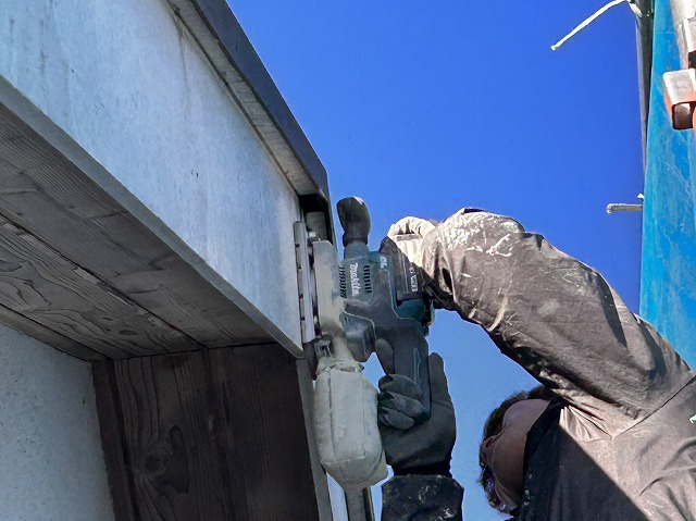 伊那市：破風板に工具でケレンを行う塗装工