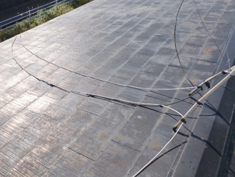 豊島区　棟板金飛散と屋根の点検　南側は苔が生えておらずと塗膜の剥がれが見られる