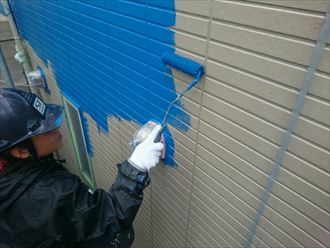 青色で外壁塗装中