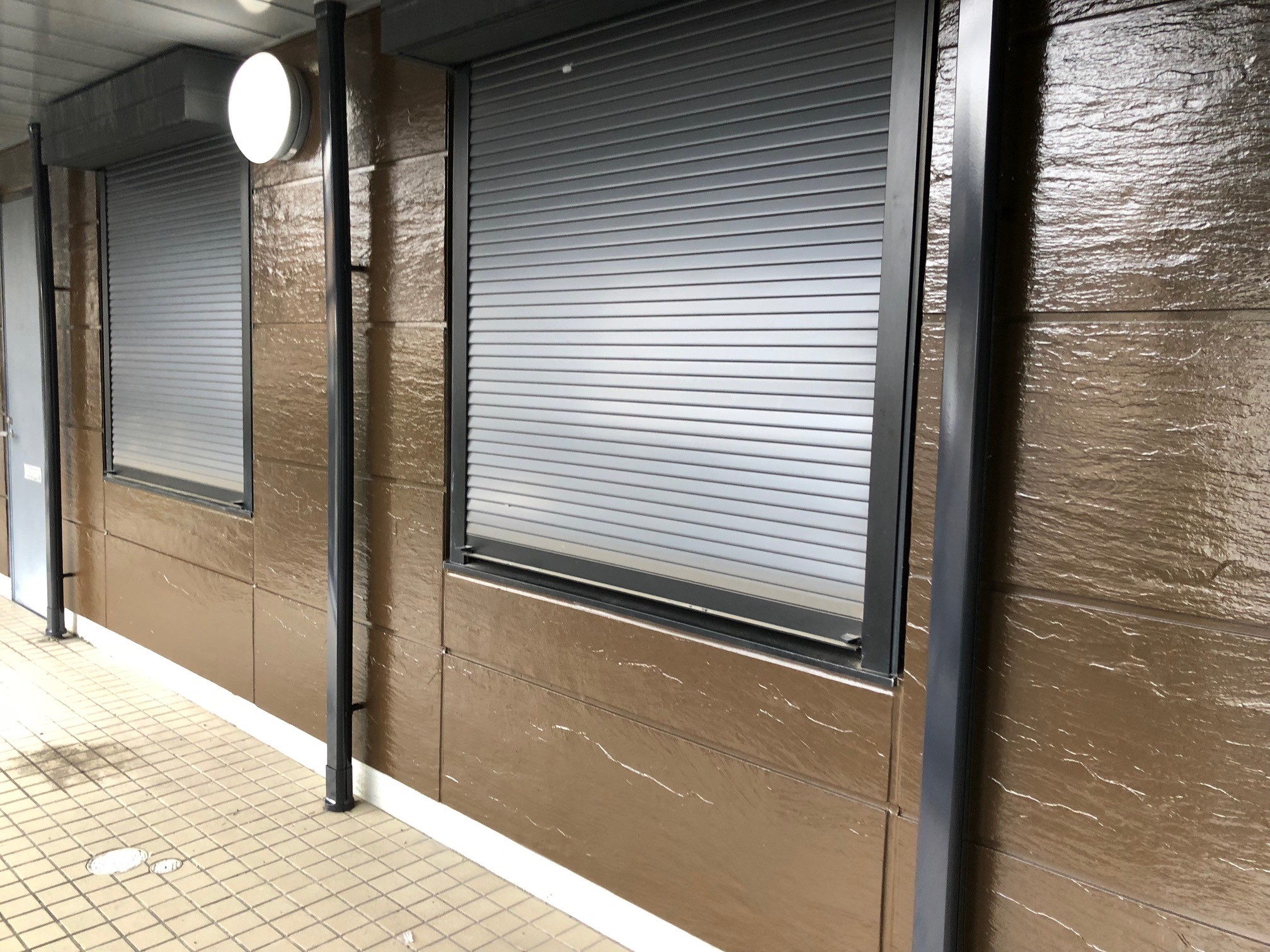 尼崎市で外壁塗装、屋上防水工事を行う現場にて、シーリング工事に並行して外壁塗装を行っています。