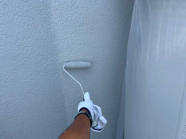 外壁をローラーで塗装中