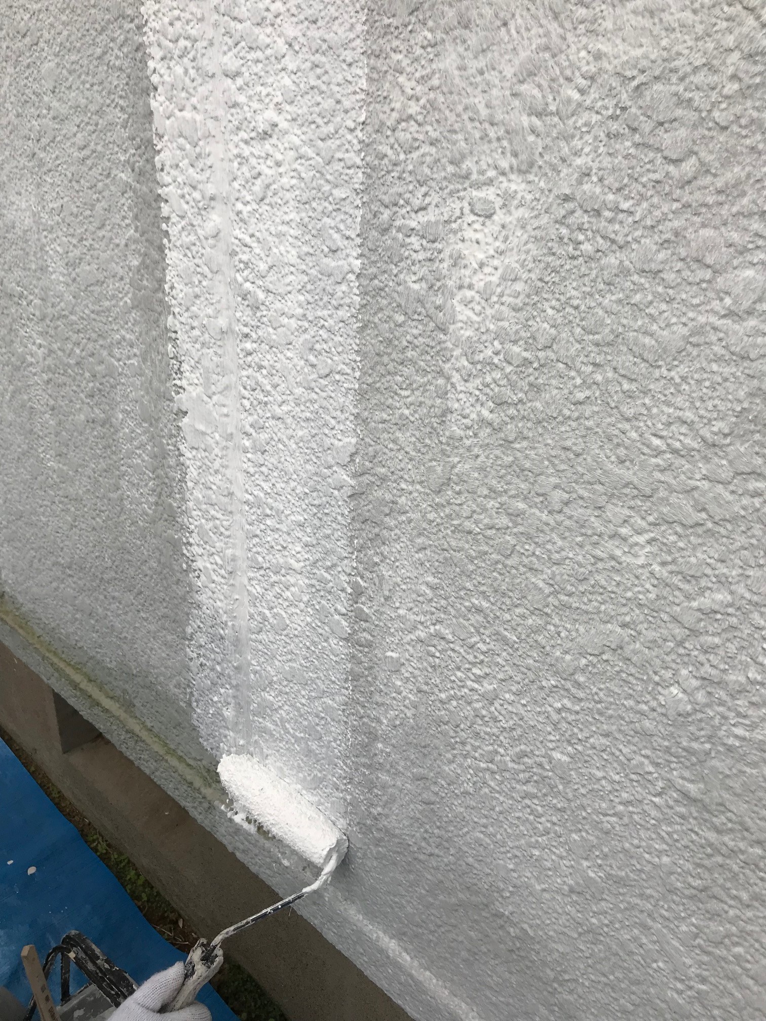 宮代町のスタッコ仕上げ外壁へはセメント系に合った塗料で下塗りです。