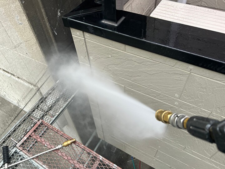 雨戸や鉄骨階段等に高圧洗浄を行っている作業風景