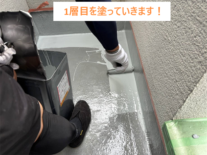 防水工事にて1層目を塗布する様子