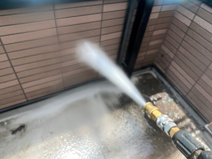 外壁に高圧洗浄している作業風景