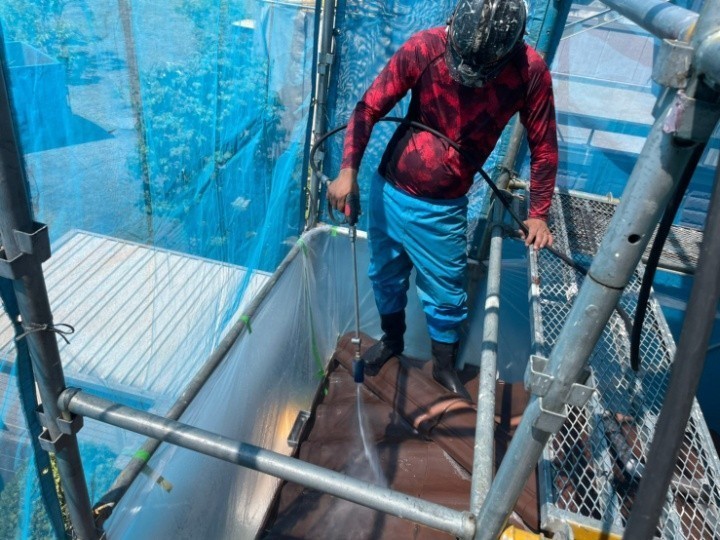 1階の屋根に高圧洗浄作する業風景