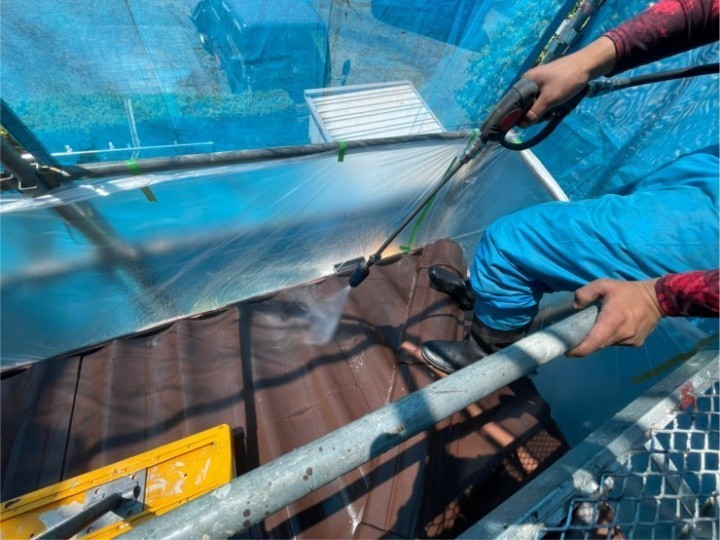 １階の屋根に高圧洗浄している風景