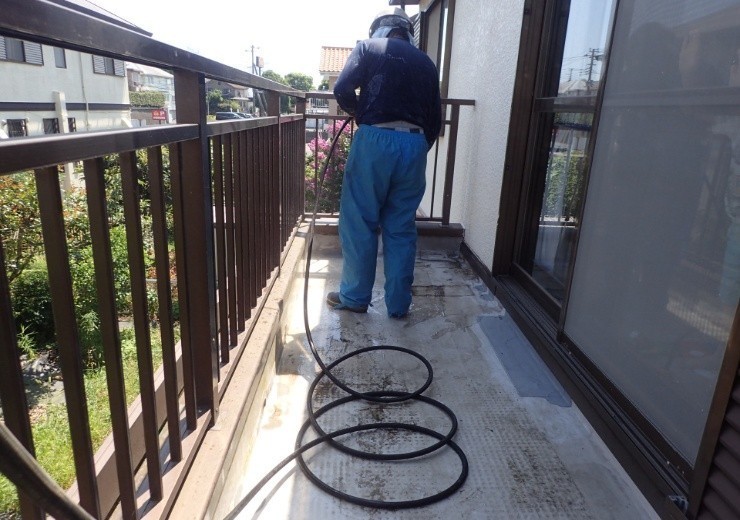 ベランダを高圧洗浄する風景