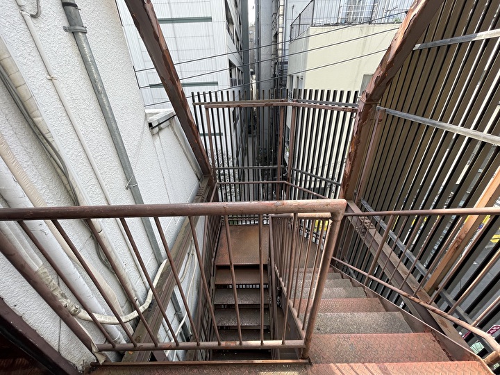 鉄骨階段のタラップの塗装が劣化し剥がれや錆が目立つ状態