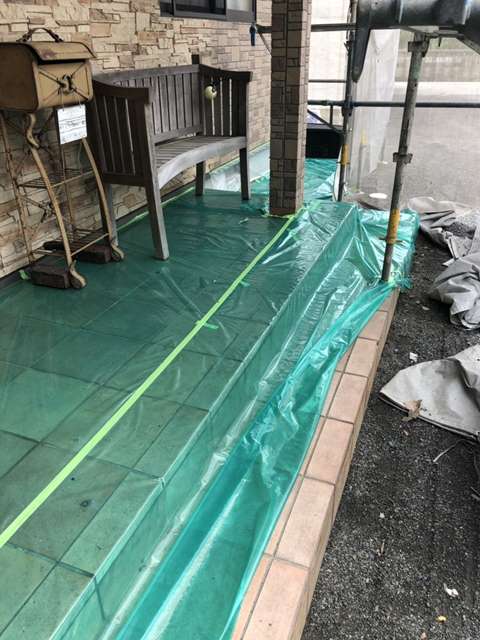 西条市外壁塗装工事。塗料の付着や汚さないために玄関、家の周り、下屋根などを養生します。