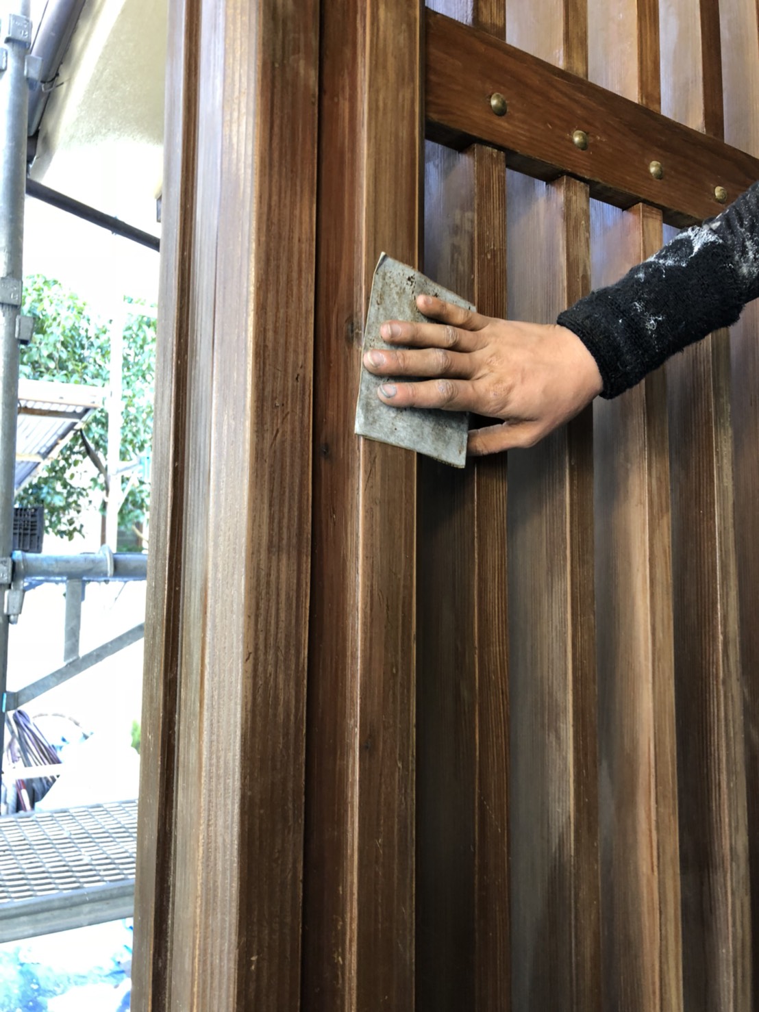 大分市田尻天領ハイツの一戸建て住宅で玄関前木部のケレン作業を行いました。