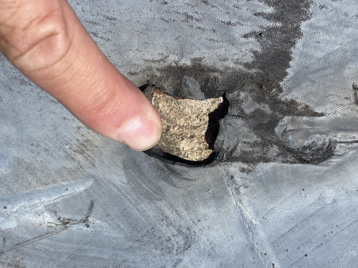 シート防水が劣化して破れ、穴が開いている様子