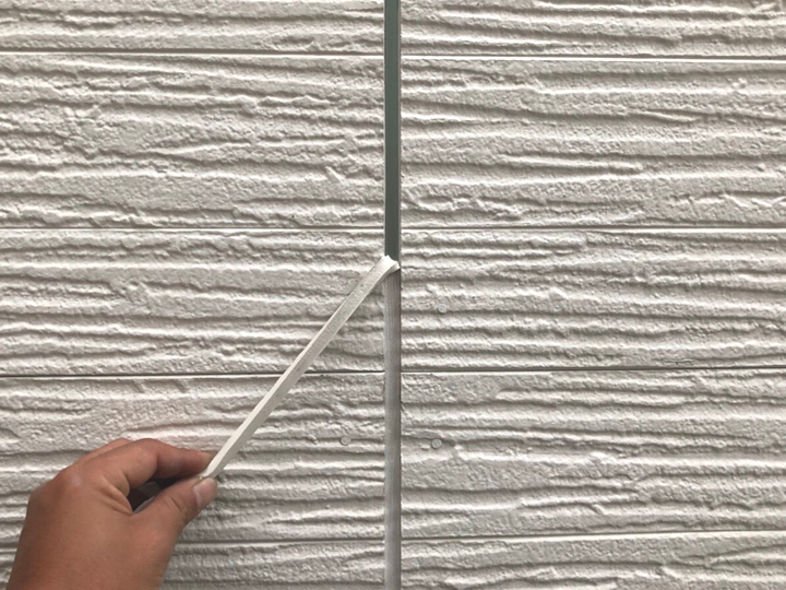 コーキング打ち替えのため、既存の劣化したコーキングを撤去している様子