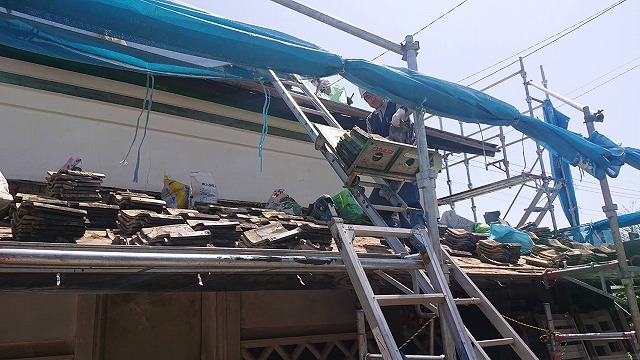 撤去した瓦屋根を荷揚げ機で降ろしている状況