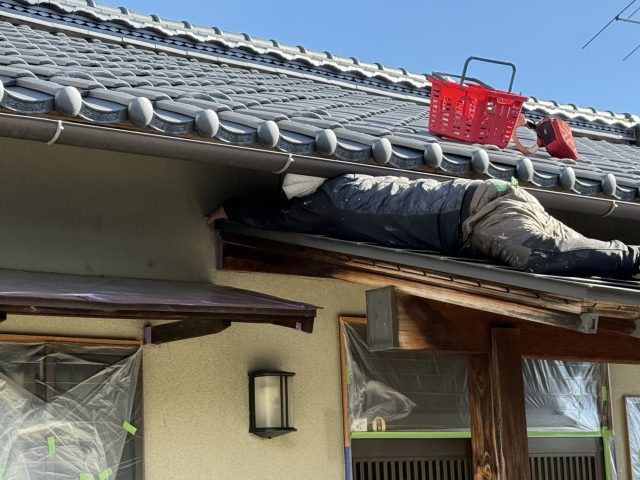 飯田市I邸_隙間に入って養生作業をする職人