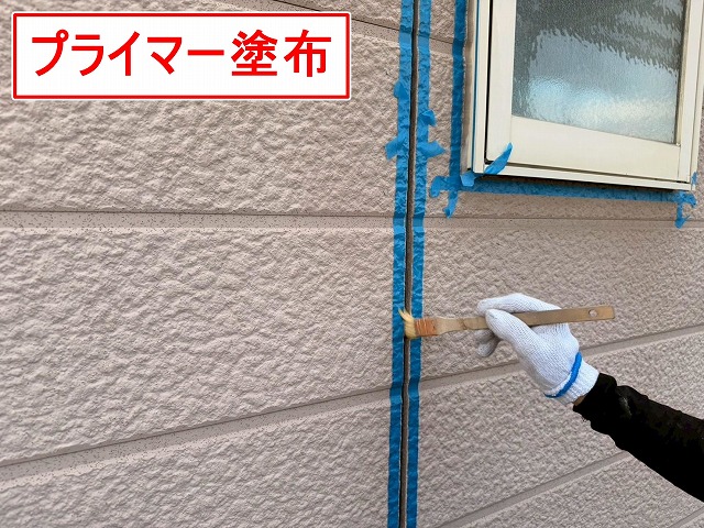 山梨市でサイディング目地にプライマーを塗布する様子（シーリング打ち替え工事）