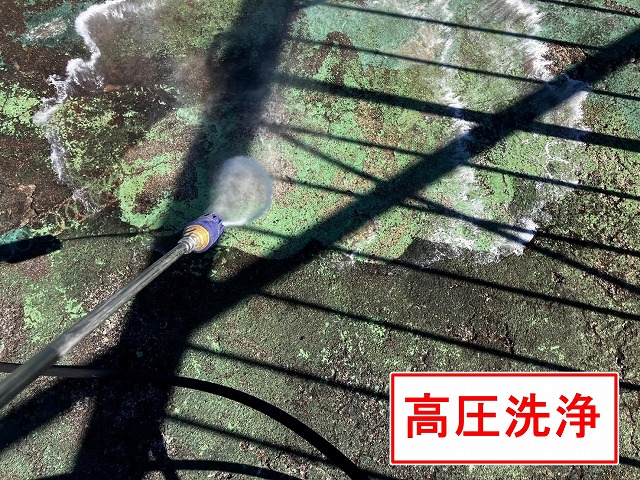 甲府市で黒ずみ汚れ・ひび割れ(クラック)の目立つ屋上防水(ウレタン防水)に高圧洗浄を行う様子