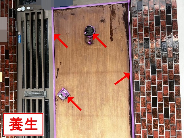 甲府市で木部の玄関扉塗装で、高圧洗浄・ケレン作業を行い下地処理する様子