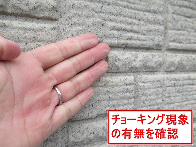 西八代郡市川三郷町で外壁のチョーキング現象を確認する様子