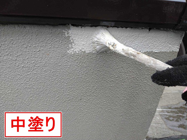 甲府市で基礎に刷毛で塗装（中塗り）を行う様子