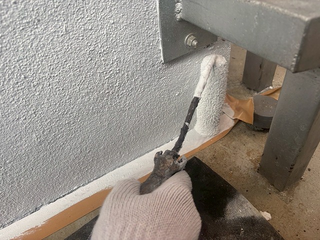 西八代郡市川三郷町でローラーを使用して基礎塗装を行う様子（基礎ガード使用）