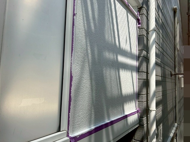 南アルプス市で黄ばみ・シミのある目隠しパネルに養生をかけて塗装する様子