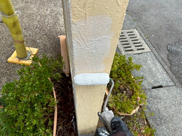 南アルプス市で目隠し擁壁に下塗り（白色）を行う様子