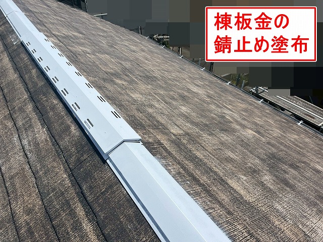 山梨市でコロニアル屋根（スレート屋根）の棟板金を錆止め塗装する様子