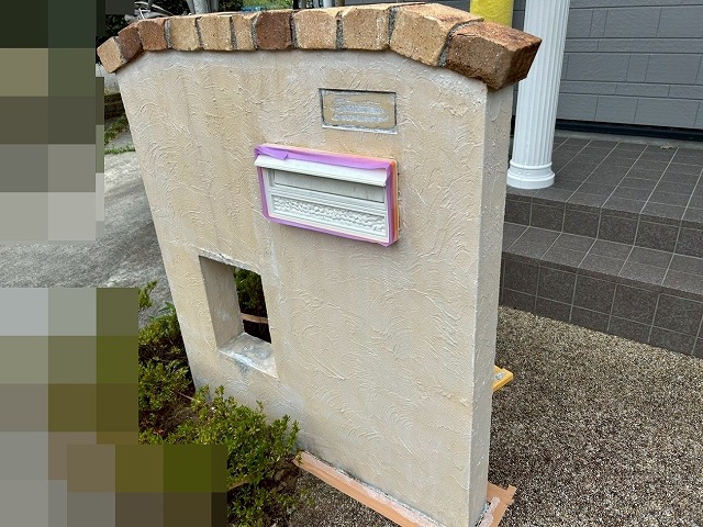 南アルプス市で目隠し擁壁に下塗り（白色）を行う様子