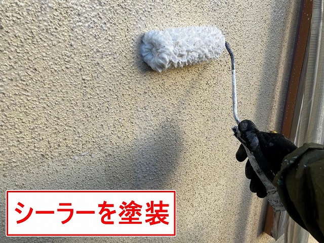 笛吹市でモルタル外壁に水性カチオンシーラーを塗装する様子(下塗り)