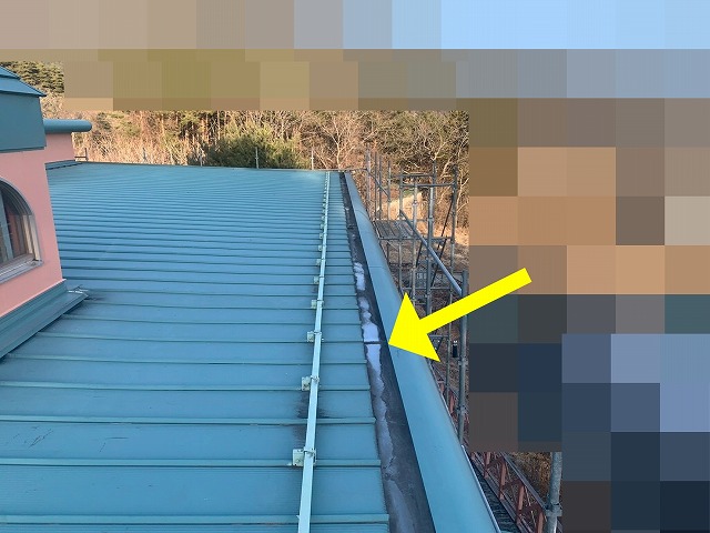 南都留郡富士河口湖町で観光ホテルの箱樋（雨樋）の継ぎ目にシーリング補修（コーキング補修）を行う様子