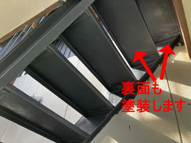 甲府市で塗膜剝がれ・錆びの発生した鉄部階段にケレン作業後、錆止め塗装(下塗り)を行う様子