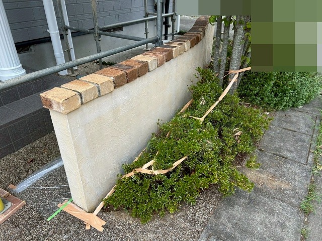 南アルプス市で目隠し擁壁に下塗り（白色）を行う様子