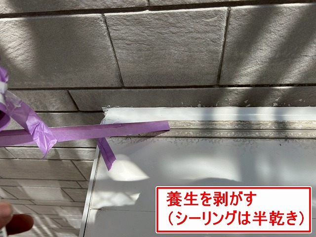 南アルプス市で窓・ドア・換気フードのサッシ廻りにシーリング材が半乾きで養生を撤去する様子(シーリング増し打ち工事)