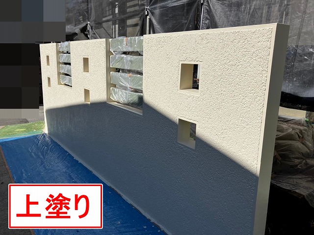 笛吹市でクラック(ひび割れ)の目立つ擁壁に塗装(上塗り)を行う様子
