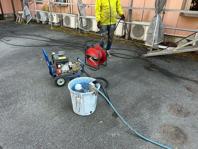 南都留郡富士河口湖町で観光ホテルの外壁塗装前に高圧洗浄を行う様子（メッシュシート設置）