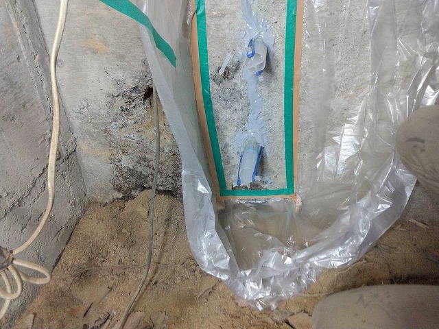西八代郡市川三郷町で倉庫の外壁基礎をエポキシ樹脂の充填でひび割れ補修する様子