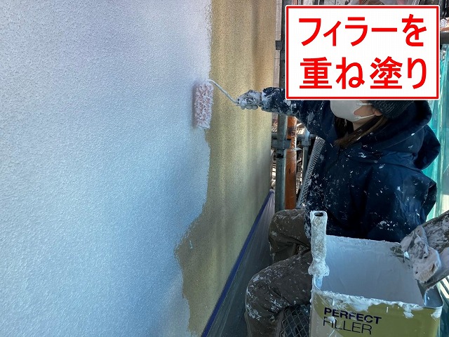 笛吹市でモルタル外壁にパーフェクトフィラーを塗装する様子(下塗り)