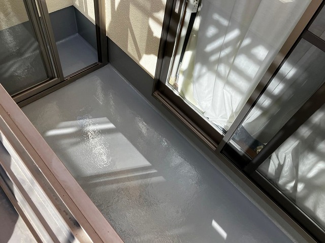 笛吹市でベランダ(バルコニー)の防水面にトップコートを2回塗り重ねる様子