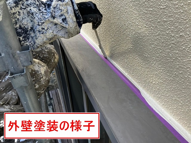 笛吹市で窓サッシ廻り(上部)にシーリング処理後、外壁塗装を行う様子