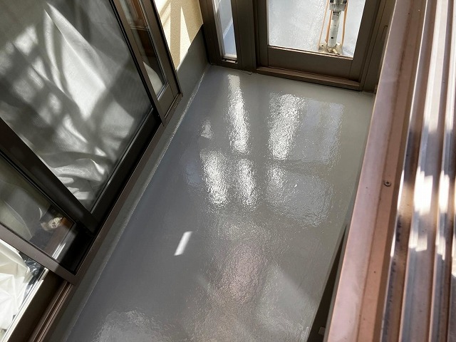 笛吹市でベランダ(バルコニー)の防水面にトップコートを2回塗り重ねる様子