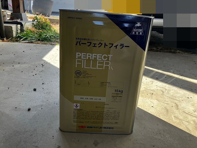 笛吹市でモルタル外壁にパーフェクトフィラーを塗装する様子(下塗り)