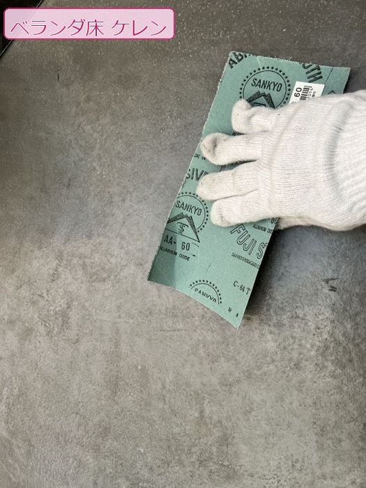 八尾市太子堂のO様邸 ベランダ床面にサンドペーパーをあてケレン作業をしている職人の手元