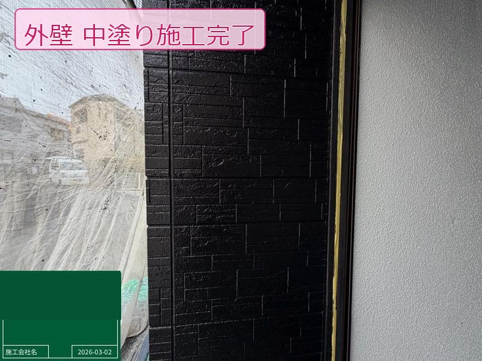 松原市別所のO様邸 石積み調サイディング外壁の中塗り完了後 深いブラック系塗料で均一に仕上がった状態