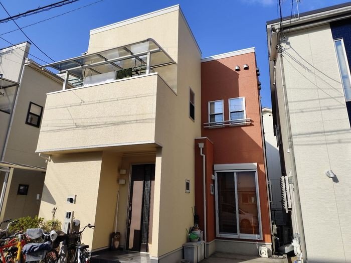 八尾市O様邸外壁塗装施工後の建物全景。クリーム×テラコッタの2トーンに生まれ変わった