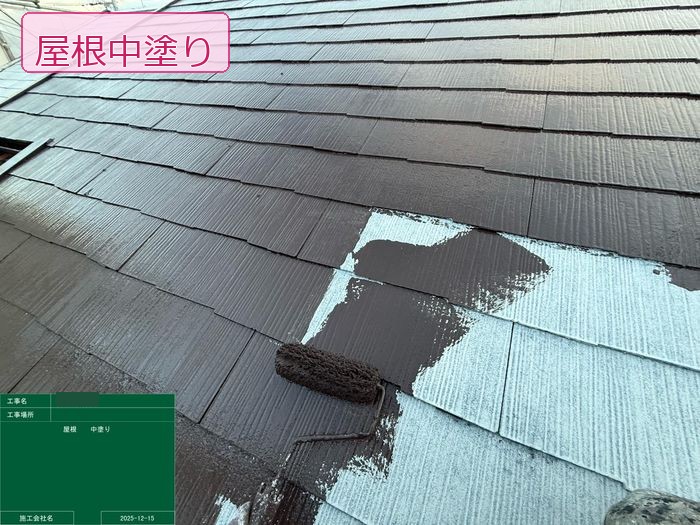 松原市別所のT様邸 スレート屋根の中塗り施工中 ローラーでブラウン系塗料を塗り広げている様子