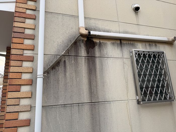 八尾市南安町の戸建て住宅 雨樋エルボ部分から外壁に広がる黒い汚れの状態