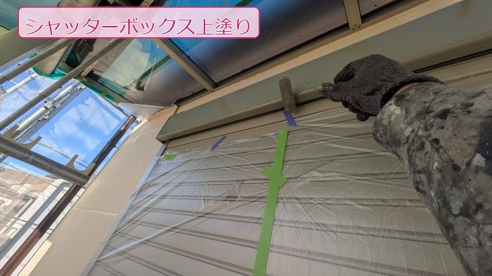 八尾市太子堂のN様邸 職人がローラーでシャッターボックスの上塗りを施工している様子