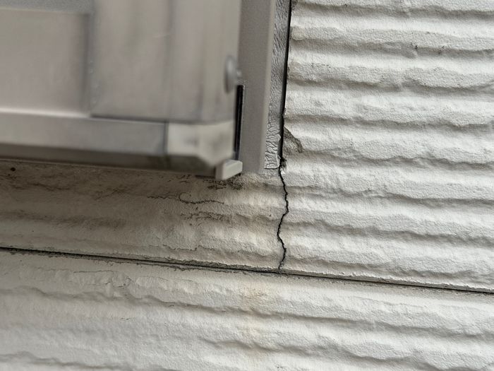 八尾市曙川東のT様邸 窓枠コーナー部分から走るクラック(ひび割れ)のクローズアップ